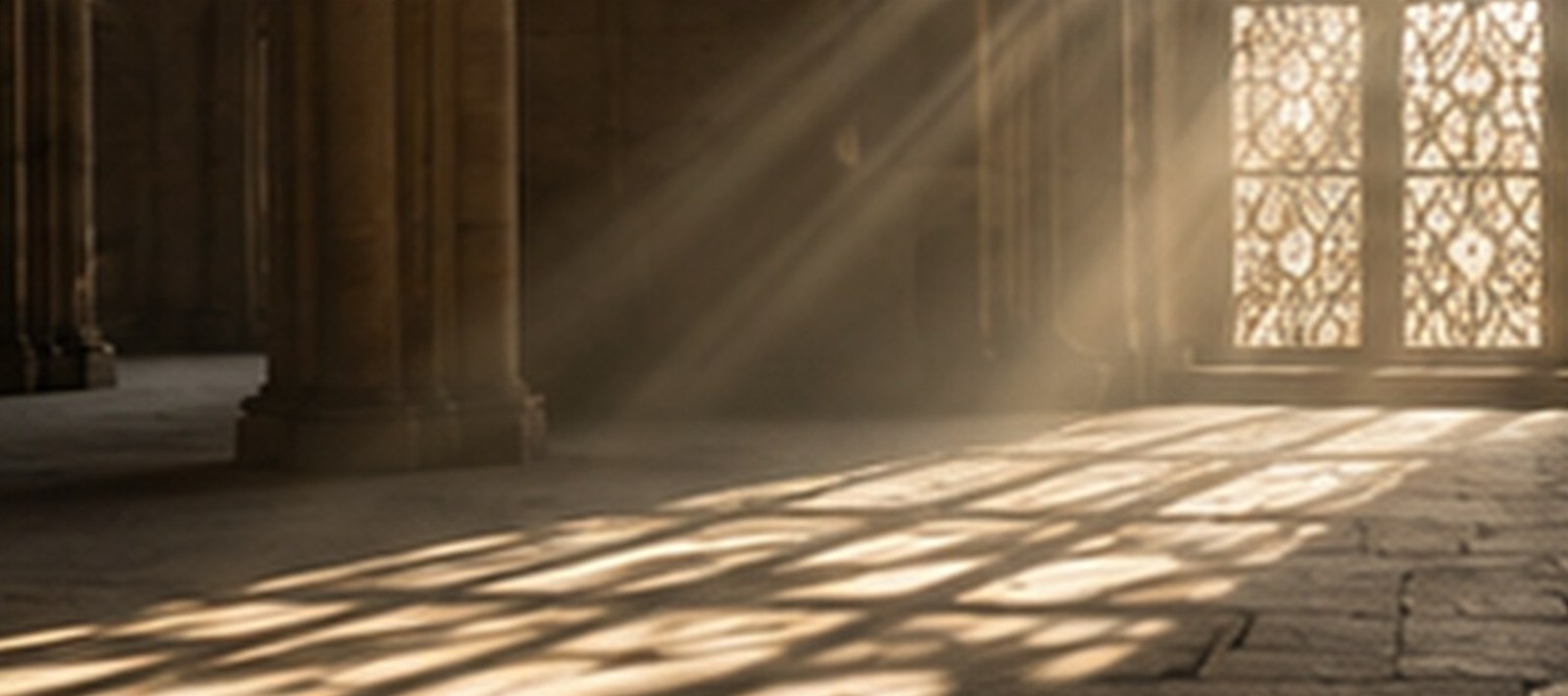Warm morning light pours through carved lattice windows and falls in patterns across the stone floor of an empty, quiet sanctuary with tall columns.