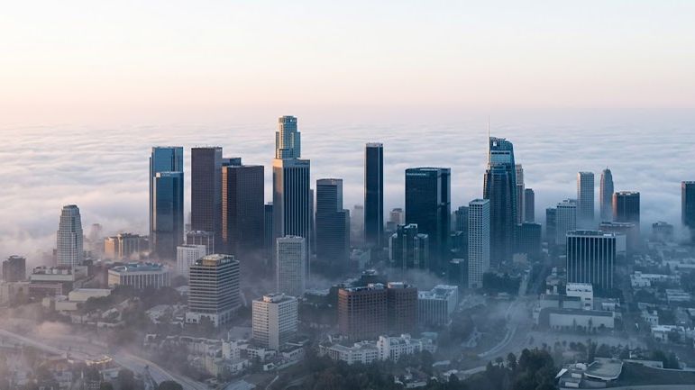 A city skyline rising out of fog